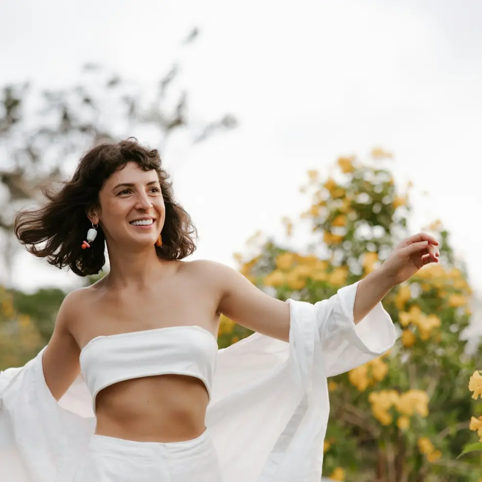 a woman in a white outfit is walking down a road