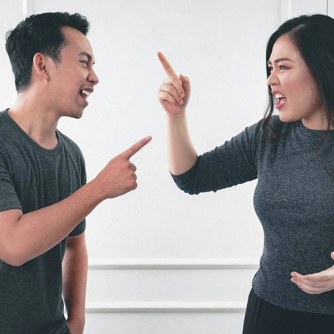 man in gray crew neck long sleeve shirt standing beside woman in black crew neck shirt