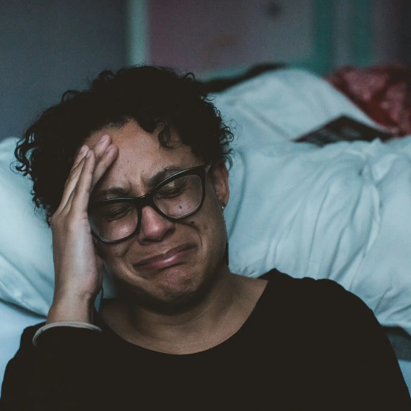 person crying beside bed
